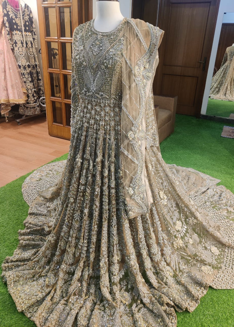 Elaborately designed dress on a mannequin in a store setting with other dresses in the background.
