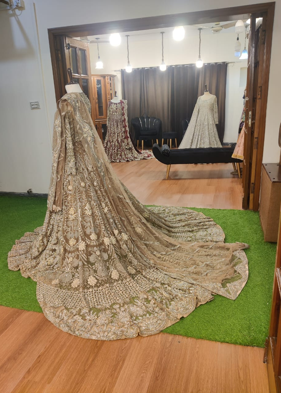 Elegant embroidered saree on a green carpet with a mirror reflection.