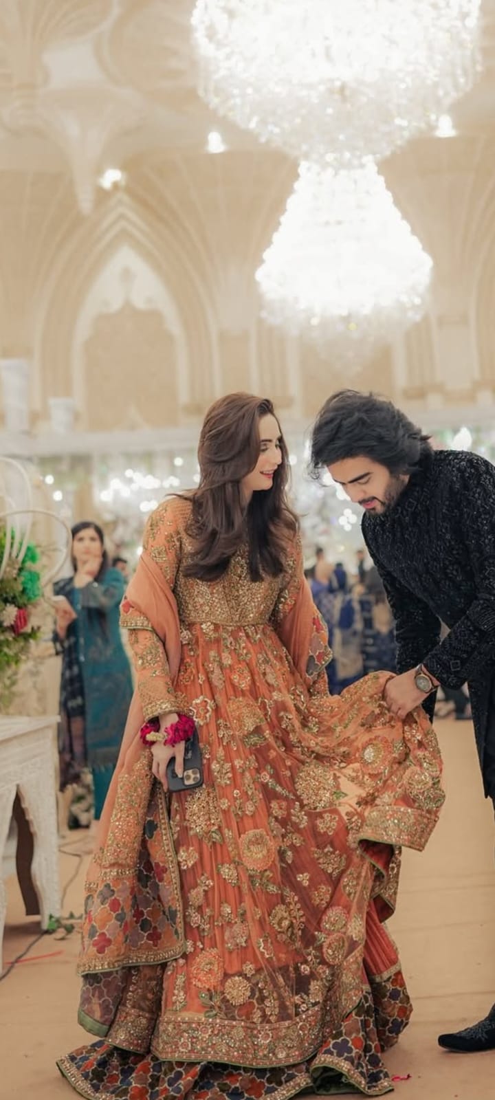 Woman in traditional outfit with floral patterns standing indoors, possibly in a formal event setting.Saaz by Hussain Rehar